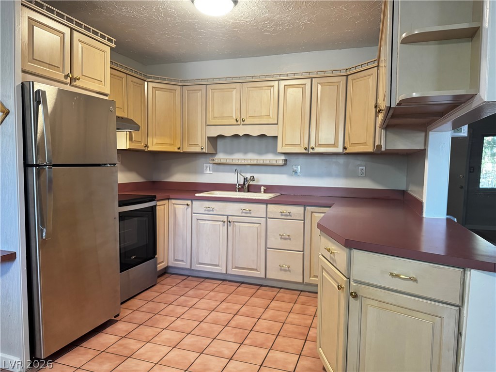 350 East Desert Inn Road, Unit C103 Las Vegas, NV 89109 - Photo 13 of 23 A functional kitchen boasts ample cabinetry and a tiled floor, ready for culinary endeavors.