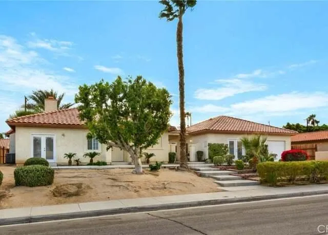 a front view of a house with a garden
