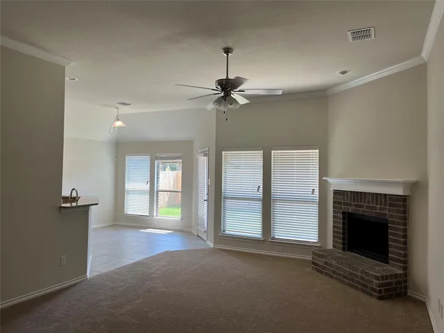 an empty room with windows and fireplace