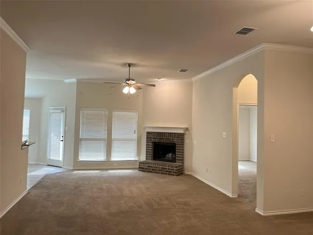 a view of empty room with fireplace and fan