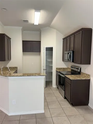 a kitchen with stainless steel appliances granite countertop a stove a sink and a microwave