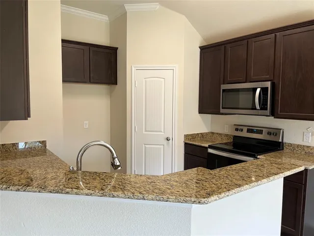 a kitchen with stainless steel appliances granite countertop a stove microwave and sink