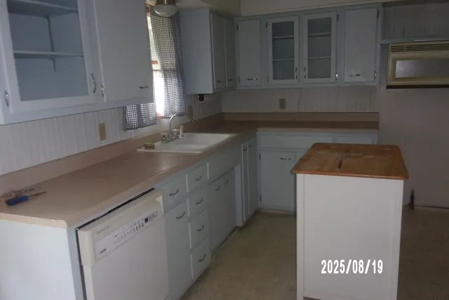a kitchen with granite countertop a sink and a stove