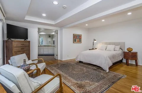 a bedroom with a bed and flat screen tv