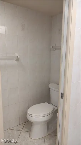 a white toilet sitting next to a shower