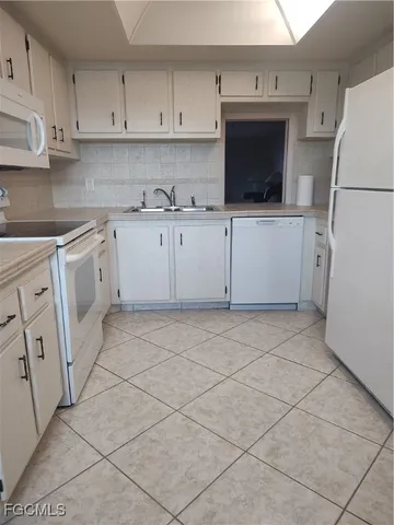 a kitchen with cabinets and white appliances