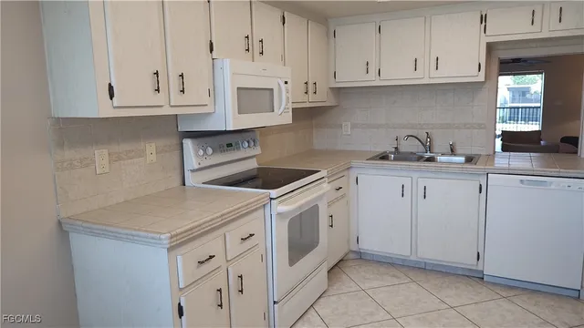 a kitchen with white cabinets and white appliances