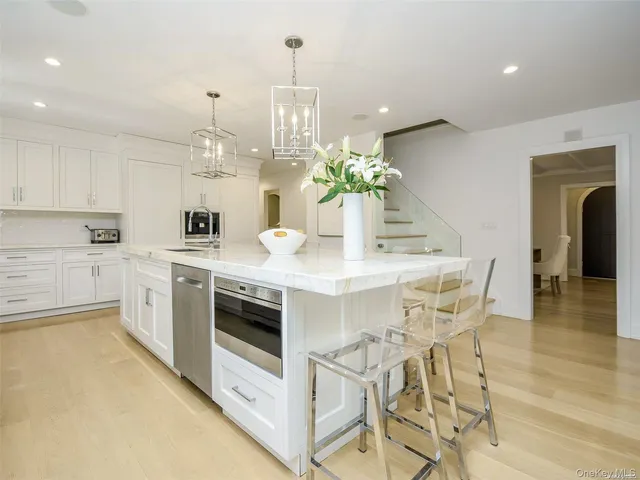 a kitchen with stainless steel appliances a white table chairs and a refrigerator