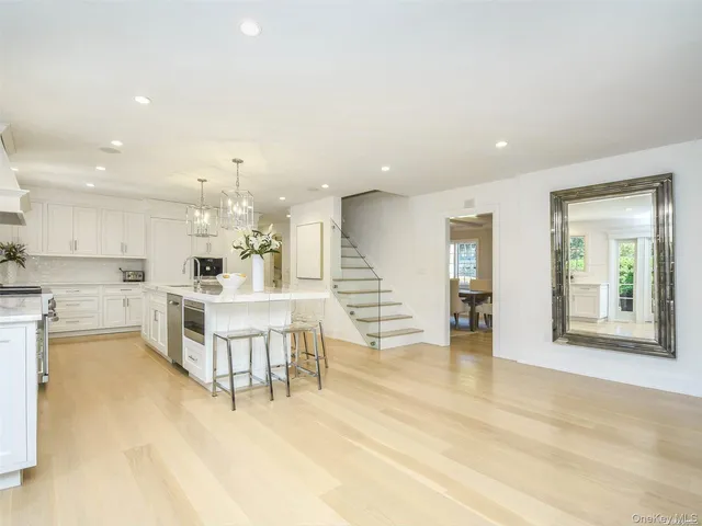 a large white kitchen with lots of counter space and furniture