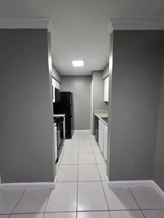 a large empty room with kitchen view
