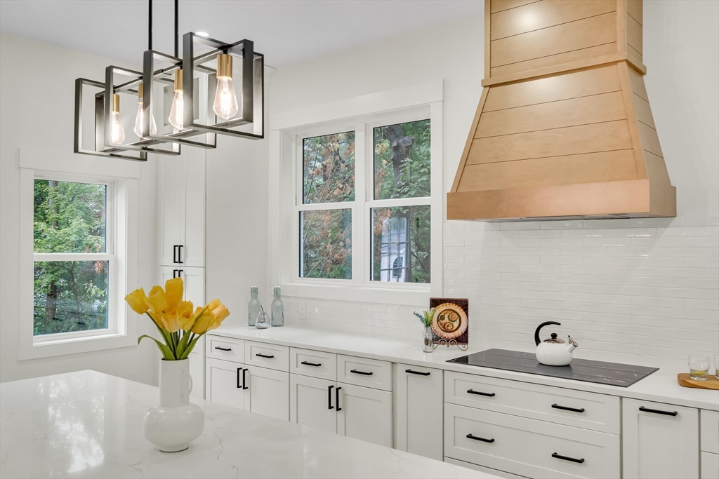 22 Estabrook Road Lexington, MA 02421 - Photo 15 of 36 a kitchen with stainless steel appliances kitchen island granite countertop a sink a window and white cabinets