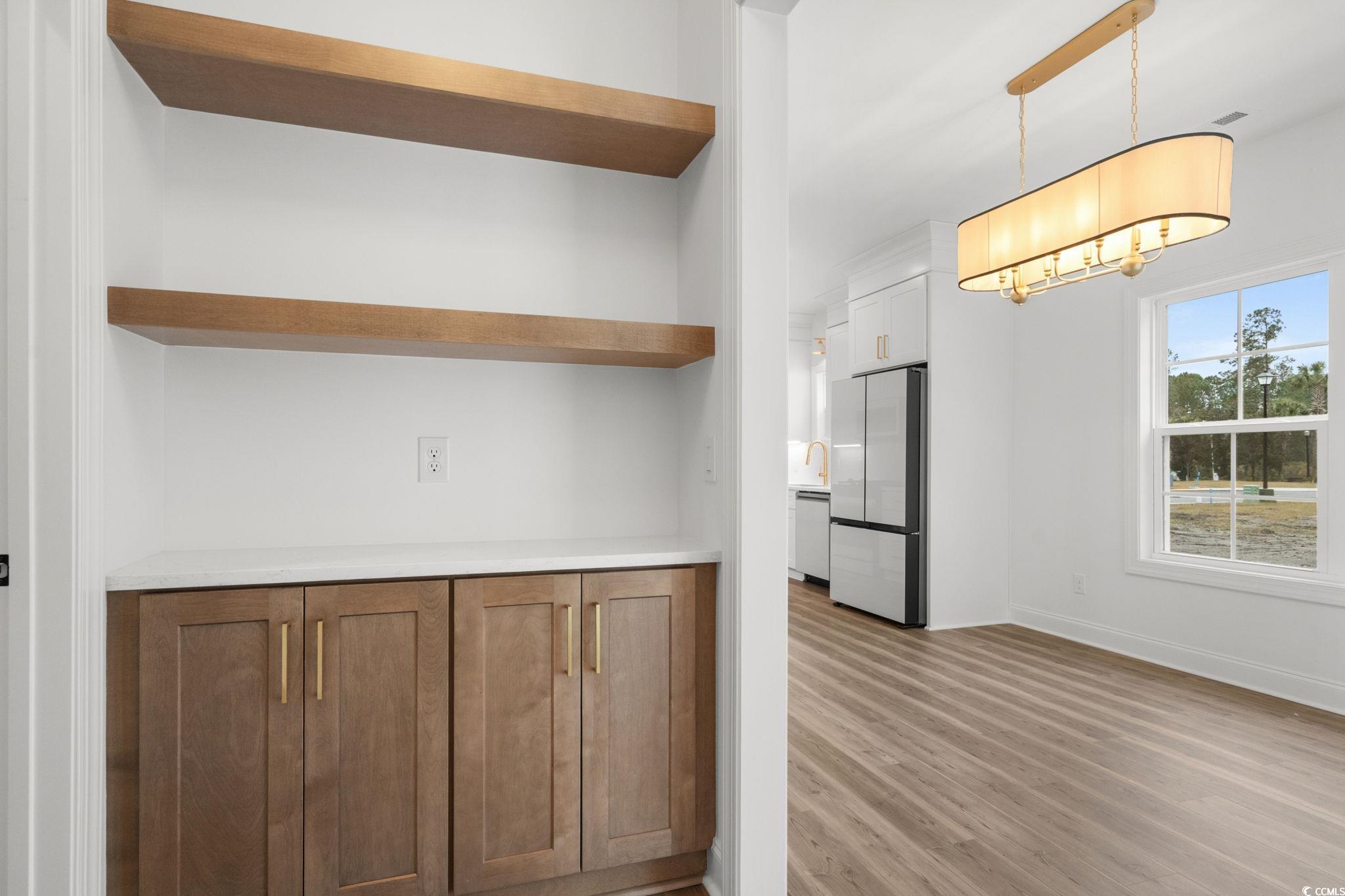 164 Arbor Ridge Circle Conway, SC 29526 - Photo 14 of 38 Kitchen with freestanding refrigerator, light countertops, open shelves, light wood-style flooring, and decorative light fixtures