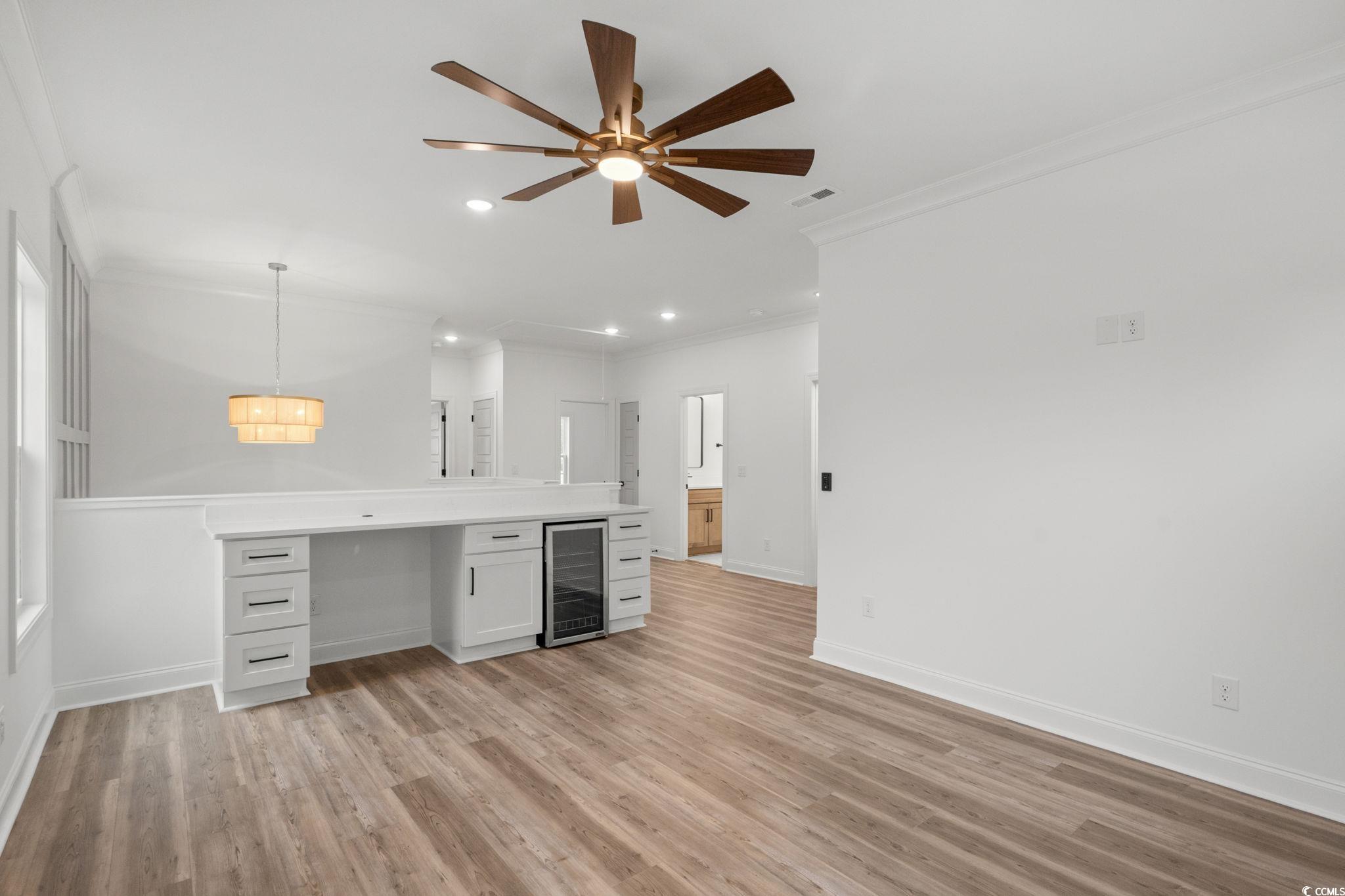 164 Arbor Ridge Circle Conway, SC 29526 - Photo 28 of 38 Kitchen featuring pendant lighting, white cabinetry, light countertops, beverage cooler, and crown molding