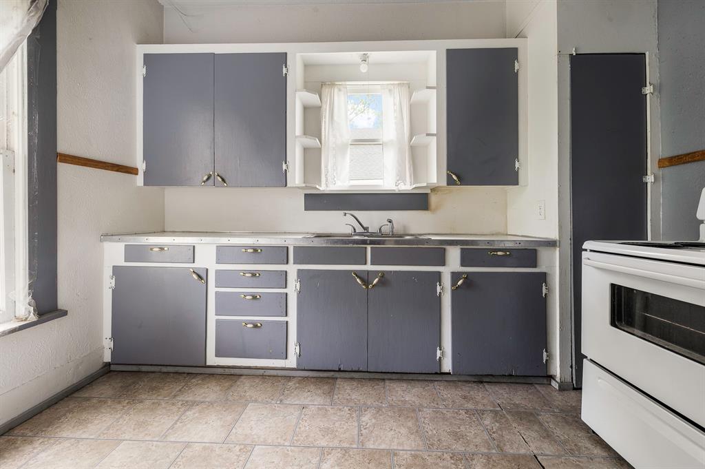 719 West Tarleton Street Stephenville, TX 76401 - Photo 12 of 30 a view of cabinets a sink and a stove in a room