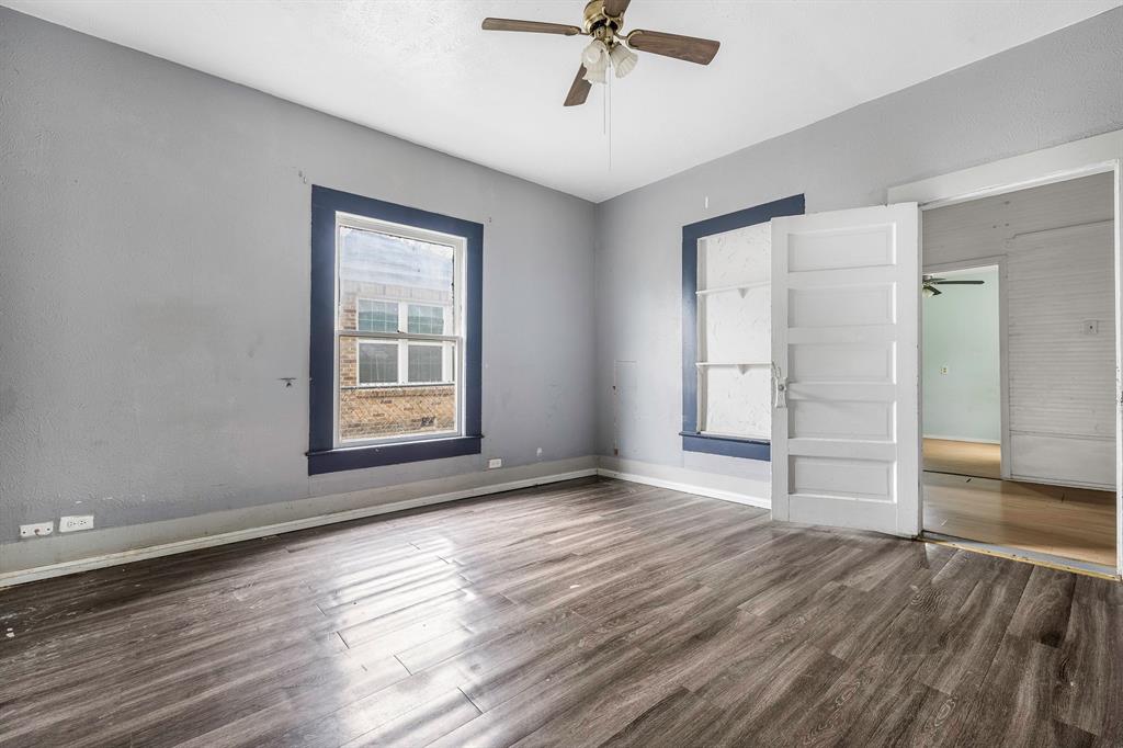 719 West Tarleton Street Stephenville, TX 76401 - Photo 17 of 30 a view of an empty room with a window and wooden floor