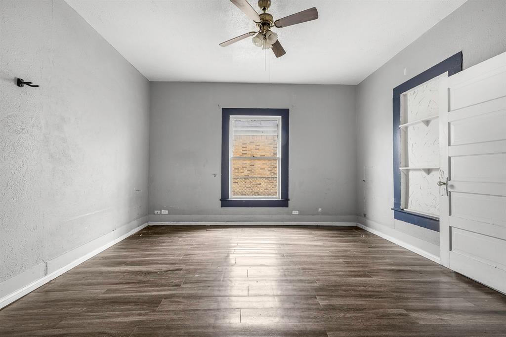 719 West Tarleton Street Stephenville, TX 76401 - Photo 20 of 30 a view of an empty room with wooden floor and a window