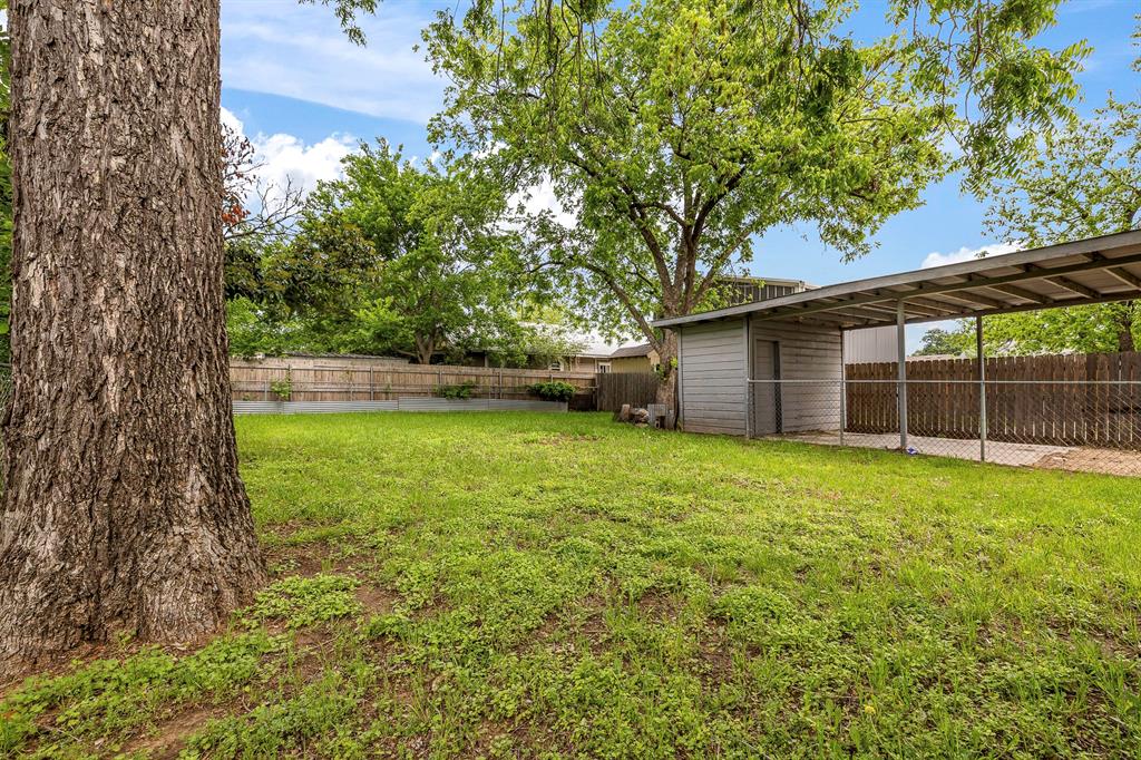 719 West Tarleton Street Stephenville, TX 76401 - Photo 27 of 30 a view of a backyard with a garden and tree