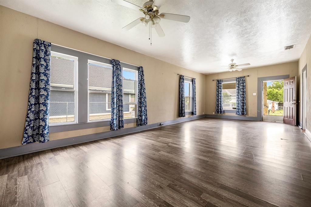 719 West Tarleton Street Stephenville, TX 76401 - Photo 4 of 30 an empty room with wooden floor and windows