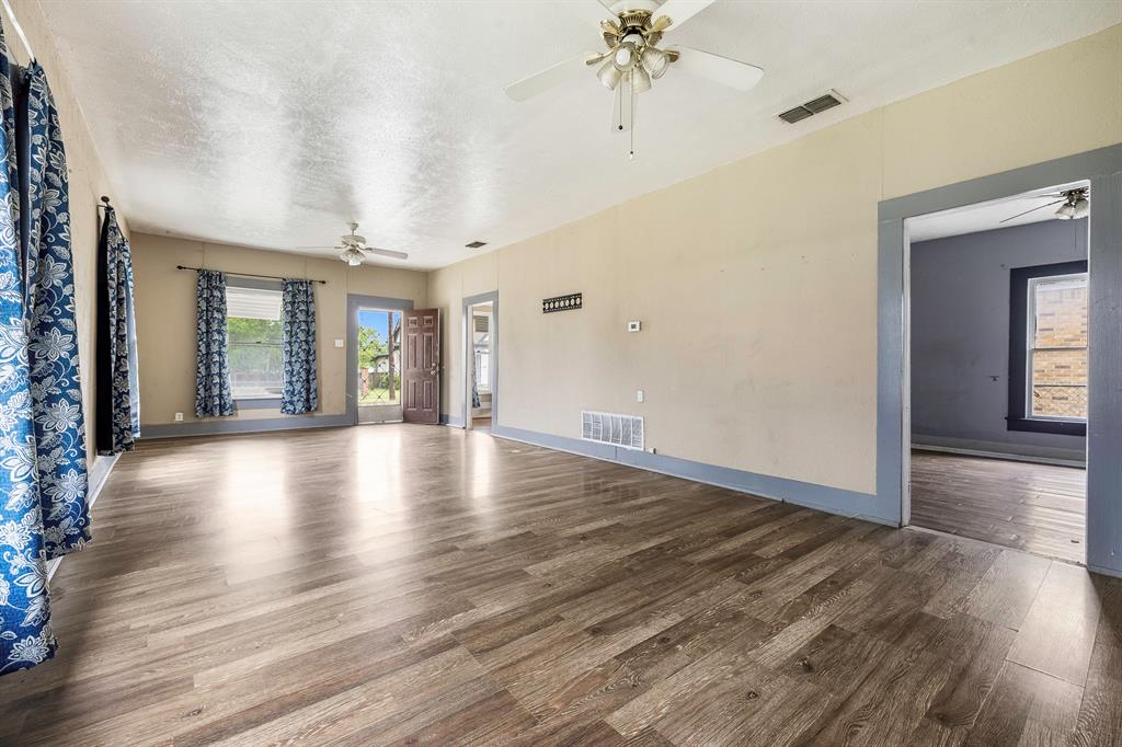 719 West Tarleton Street Stephenville, TX 76401 - Photo 6 of 30 wooden floor in an empty room with a window