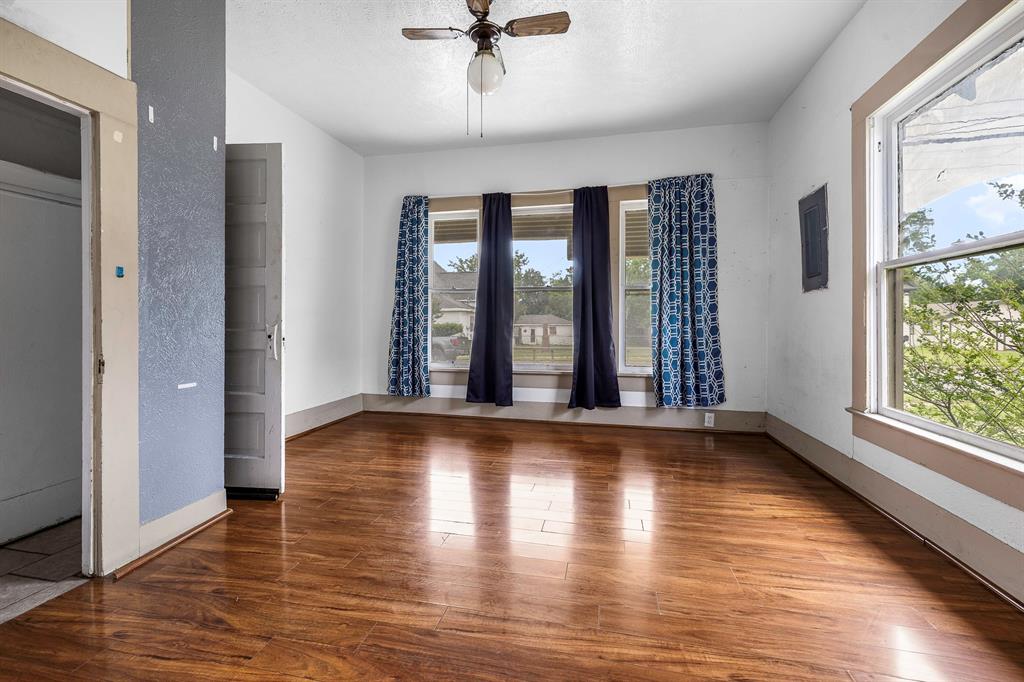 719 West Tarleton Street Stephenville, TX 76401 - Photo 7 of 30 wooden floor in an empty room with a window