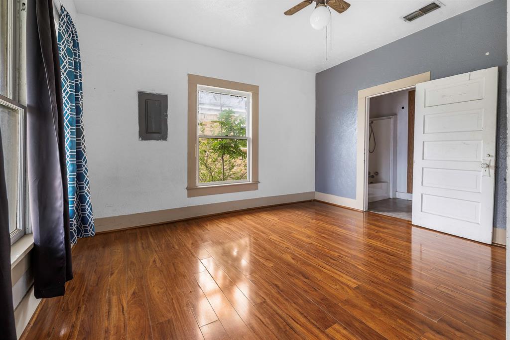 719 West Tarleton Street Stephenville, TX 76401 - Photo 10 of 30 an empty room with wooden floor and windows