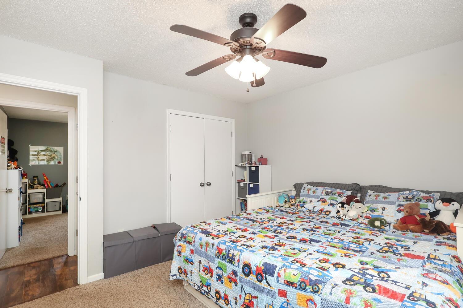 210 King George Lane Gastonia, NC 28056 - Photo 17 of 19 a bedroom with a bed and a chandelier