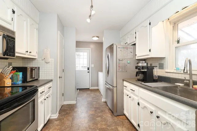 a kitchen with stainless steel appliances granite countertop a stove a sink and a microwave