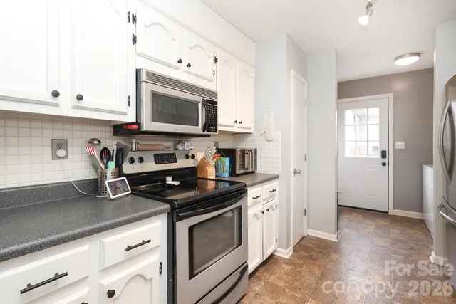 a kitchen with stainless steel appliances a refrigerator sink and cabinets