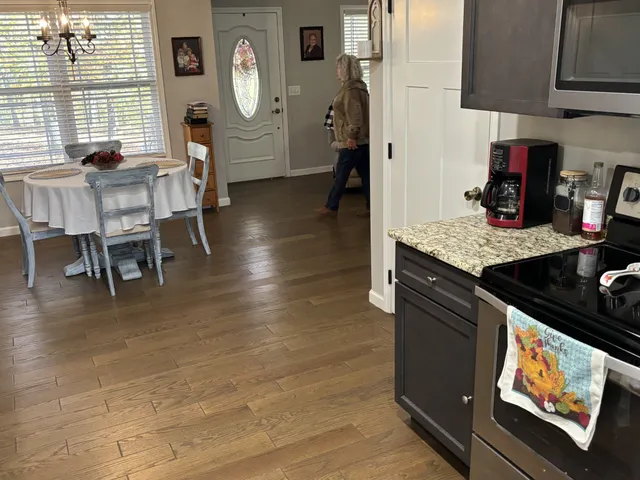 a living room with furniture a clock on wall and a window