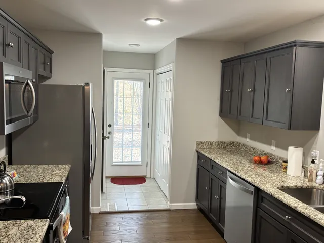 a kitchen with stainless steel appliances granite countertop a refrigerator and a stove