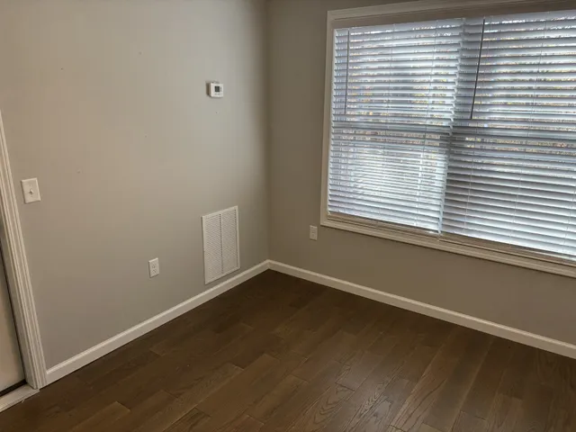 an empty room with wooden floor and a window