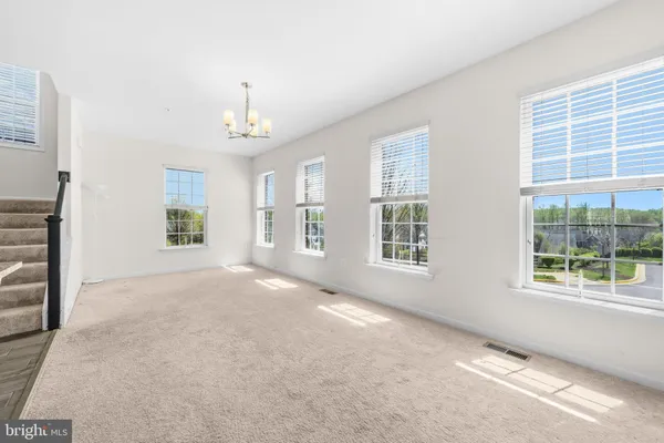 a view of an empty room with kitchen view and a window