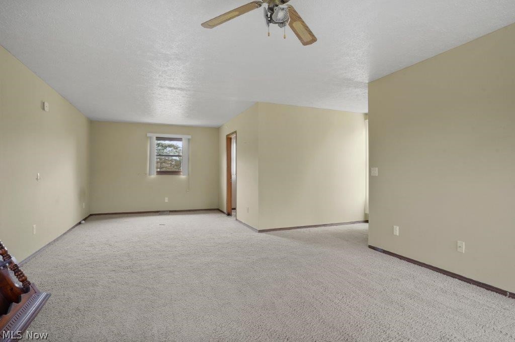 4325 Mayfair Road Uniontown, OH 44685 - Photo 22 of 35 Empty room with light colored carpet, ceiling fan, and a textured ceiling