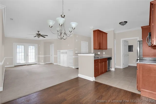 a large kitchen with granite countertop a refrigerator a stove a sink dishwasher a dining table and chairs