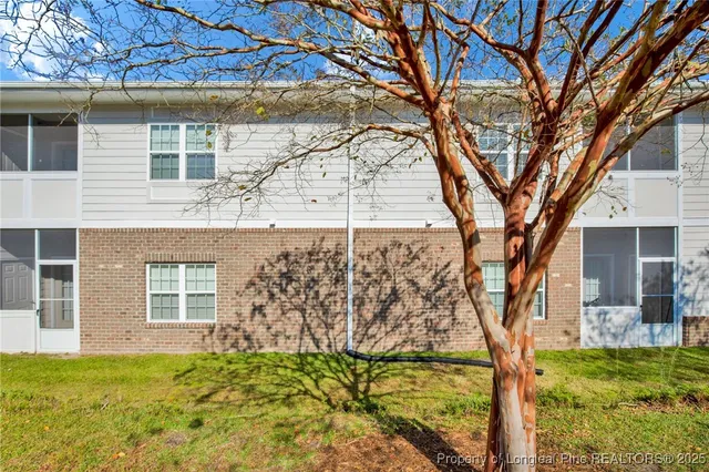 a backyard of a house with large trees and plants