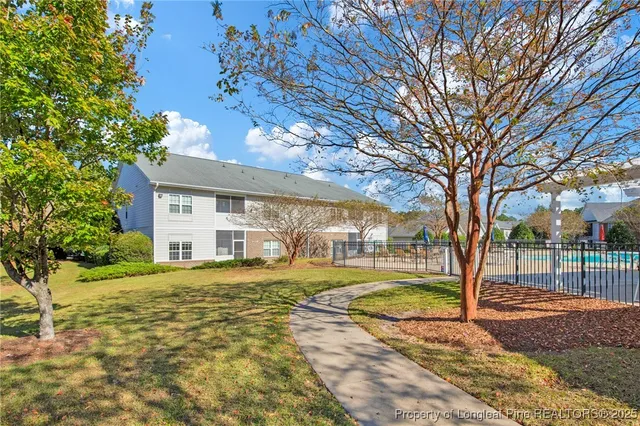 a view of a yard with plants and large trees
