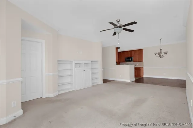 a view of a livingroom with a flat screen tv cabinets and ceiling fan