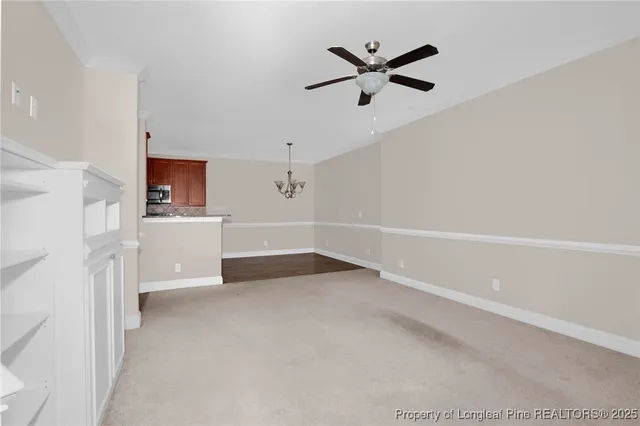 a view of a livingroom with a ceiling fan and wooden floor