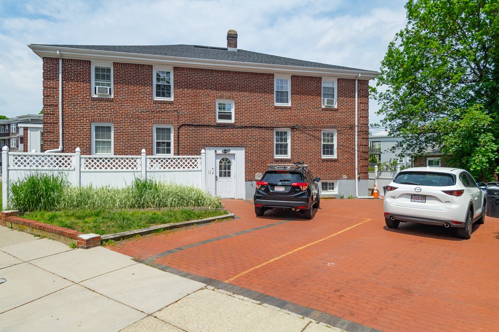 440 Adams Street, Unit 1 Boston, MA 02122 - Photo 14 of 14 a car parked in front of a brick house with a large parking space