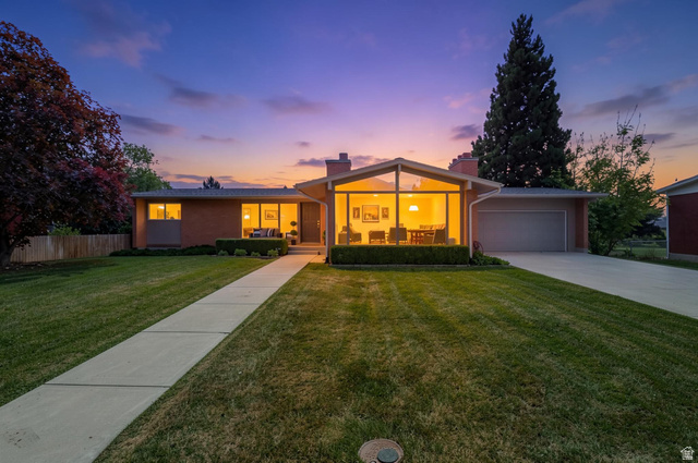 Mid-century modern residence featuring a striking A-frame window design, brick facade, and an attached garage