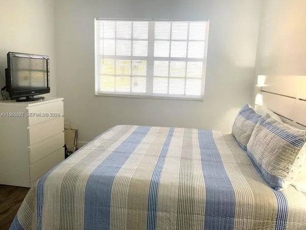 a bedroom with a bed and a television
