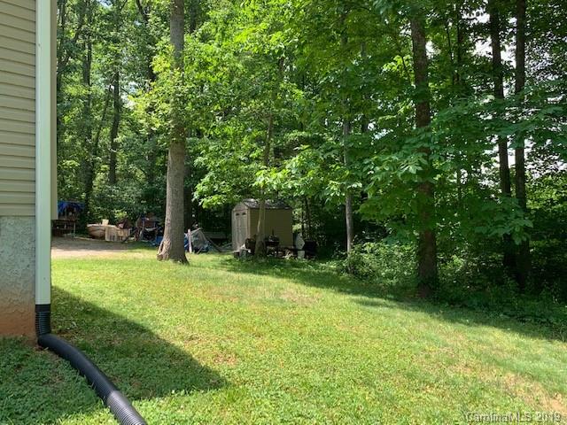 49 Ballard Ridge Road Leicester, NC 28748 - Photo 10 of 21 a backyard of a house with plants and large trees
