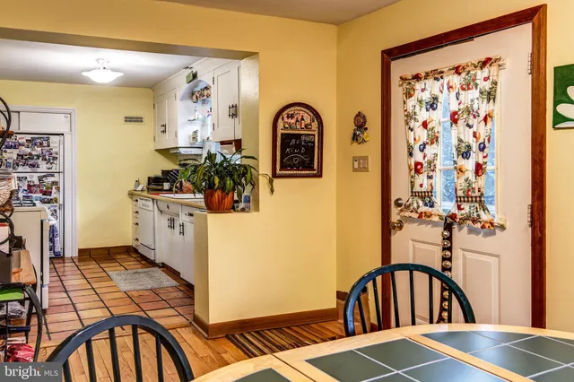 a view of a hallway to a livingroom and entryway