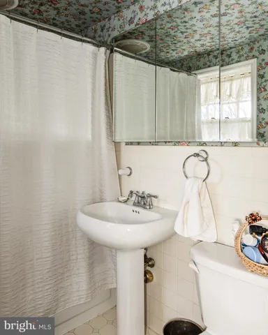 a bathroom with a sink a mirror and a shower curtain