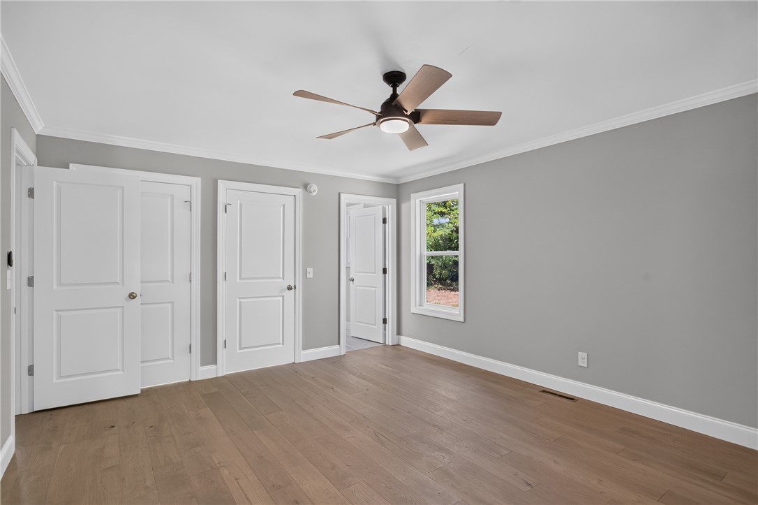 712 Beech Drive Seneca, SC 29678 - Photo 21 of 41 Hardwood flooring and crown molding appoint this adaptable bedroom space.