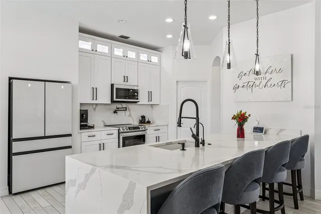 a kitchen with white cabinets and sink
