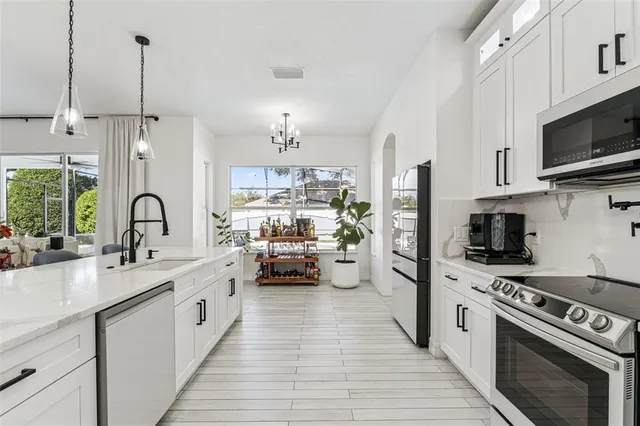 a kitchen with stainless steel appliances a sink stove and refrigerator