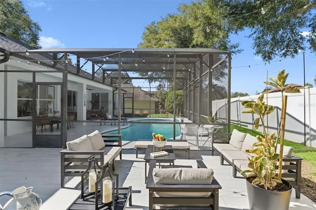 a view of a patio with couches chairs and a big yard