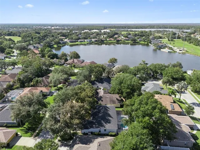 an aerial view of a houses with a yard and lake view