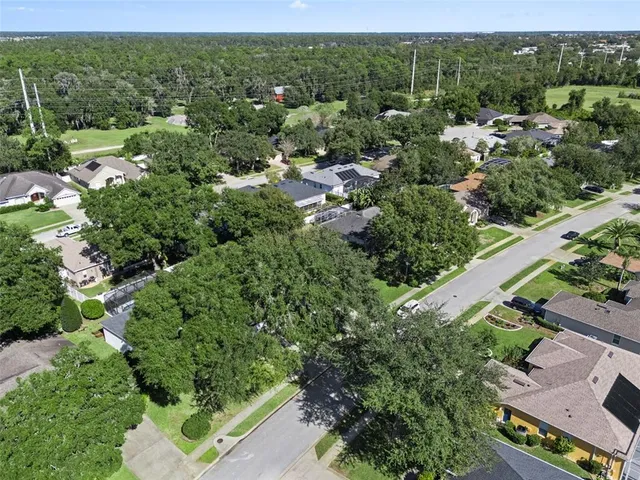 an aerial view of a house with a yard swimming pool and outdoor seating